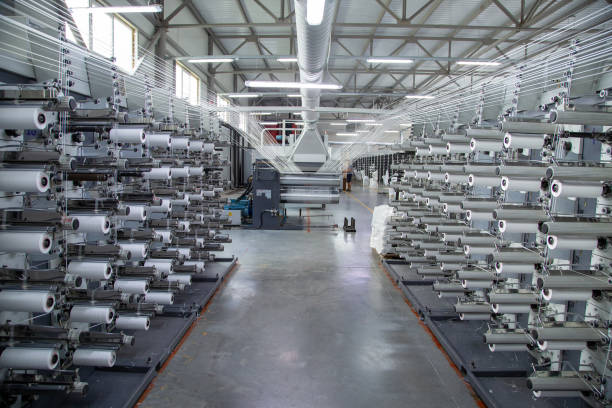 istock Factory equipment in perspective. Rows with coils of polypropylene threads for weaving cloth. Automatic machine. Nobody. 2051317481