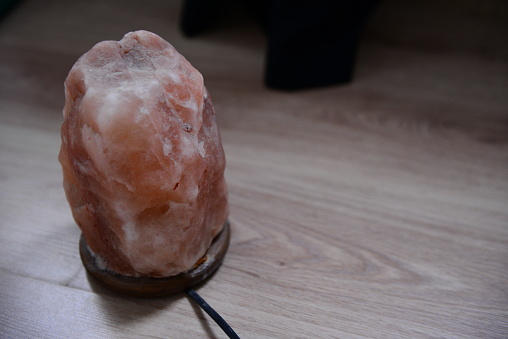 Himalayan Salt Lamp on Wooden Floor With Dim Background