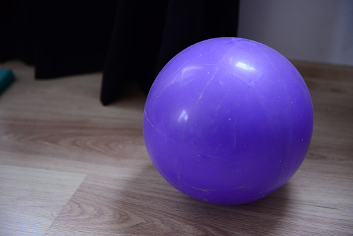 Purple Fi̇tness Ball on Wooden Floor With Dim Background