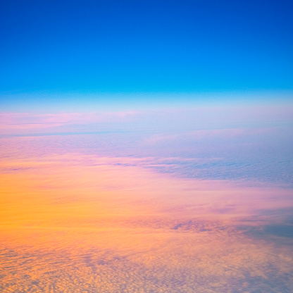 Cloudscape and blue sky at sunset, an airplane flight view over the cloud