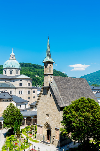 Salzburg, Salzburg - Austria - 06-17-2021: A serene view capturing St. Peter's Cemetery, Salzburg Cathedral, and Margarethenkapelle