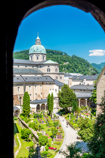 Salzburg, Salzburg - Austria - 06-17-2021: A unique perspective of Salzburg Cathedral seen through the arched window of St. Peter's catacombs