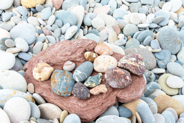 istock Colorful Rocks on Large Reddish Stone Surrounded by Pebbles 2051411278
