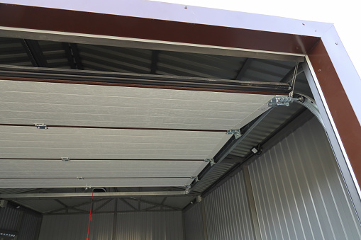 Open, raised up automatic garage door, iron structure and walls