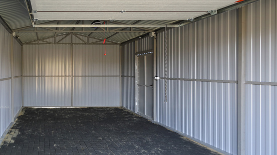 Interior of new empty iron garage, textured surface road tile on the ground