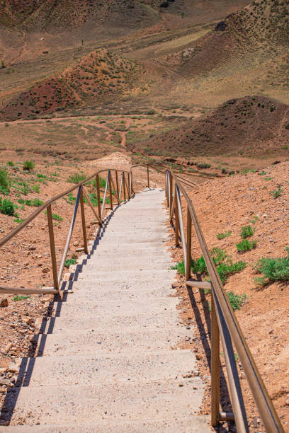 istock girl going down in desert mountains along organized stairs 2051498569