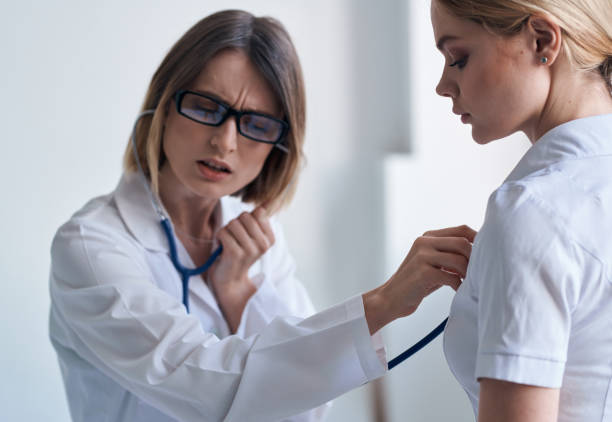 istock Doctor and patient on light blue background stethoscope health problems cropped view 2051533841