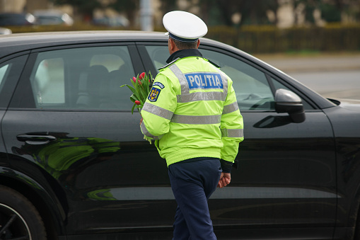 Bucharest, Romania - 1st Mar, 2024: Policemen from the Traffic Brigade prepares to offer flowers to women drivers on the occasion of Martisor, a Romanian tradition in early spring.