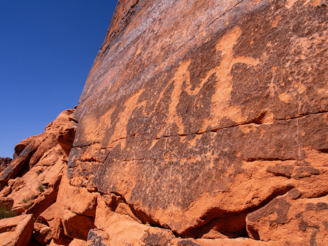 In the stunning landscape of Valley of Fire National Park, Nevada, USA, ancient Indian petroglyphs intricately adorn the rugged rock formations, offering a mesmerizing glimpse into the region's rich cultural heritage and natural beauty.