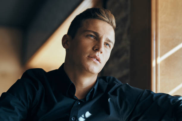 istock Handsome guy in a dark shirt at a table in a cafe restaurant sunlight model 2051603041