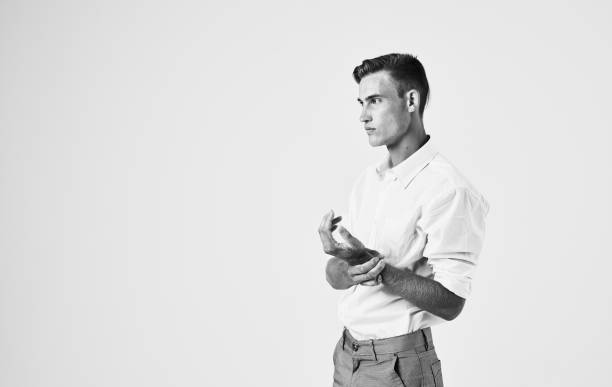 Fashionable man in suit gesturing with his hands on a light background cropped view. High quality photo