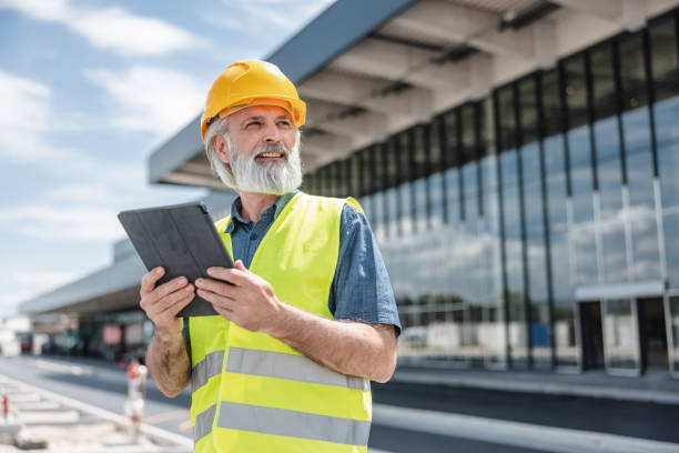 istock Attractive Mature Caucasian Male Employee Working With A Digital Tablet In A Construction Site 2051671121