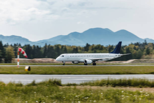 Commercial airplane moving towards a runway at the airport. Beautiful Alps in the background.
