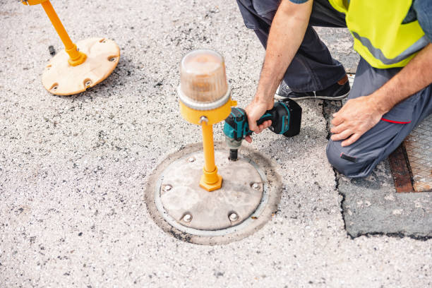 A man removes old cobblestones with a perforator. Drill, shovel, pickaxe and hammer on construction site. Road repair. Home tool.