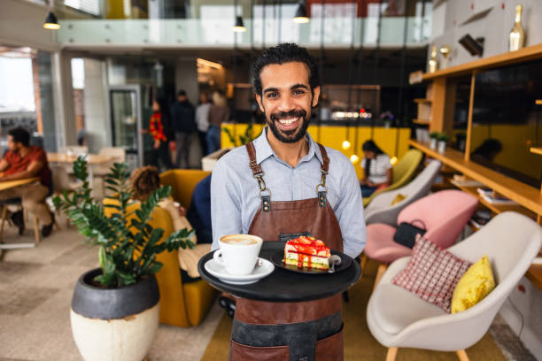 istock Confident Middle Eastern Male Bartender Smiling At The Camera While Holding A Drink Tray In A Charming Cafe 2051676720