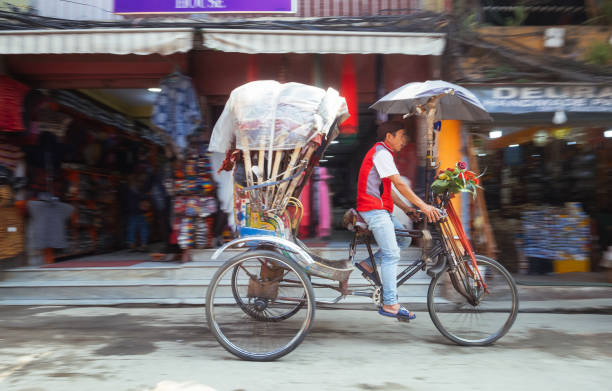 un homme de rikshaw se déplaçant rapidement dans la rue népalaise vide de la région de thamel, katmandou, népal - rickshaw nepal men indian culture photos et images de collection