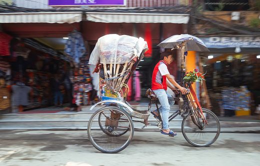 Kathmandu, Bagmati Province / Nepal - October 10,  2023: Rikshaw man moving fast on the empty Nepalese street in Thamel region, Kathmandu, Nepal
