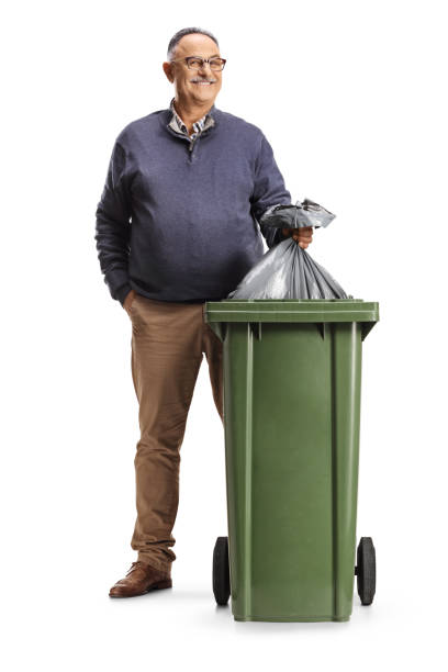 istock Smiling mature man throwing a waste bag in a dustbin 2051789352