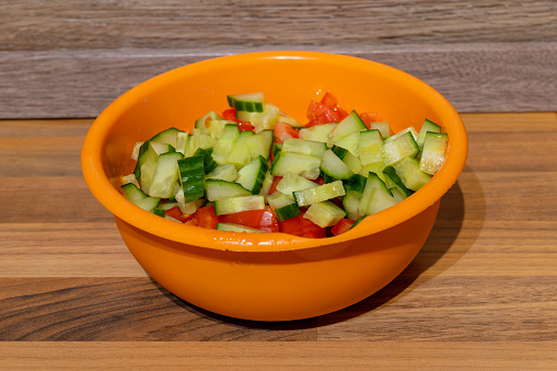 tomato and cucumber salad in a bowl in the kitchen