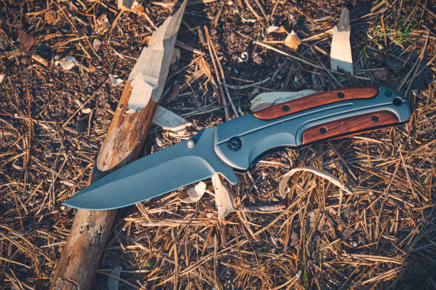 istock Folding hunting knife for survival and sharpened peg lie ground. 2051791468