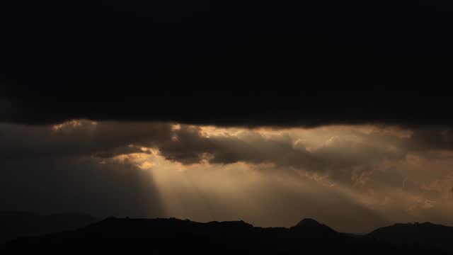 Sunset Majesty: Radiant Rays Over Mountain Peaks