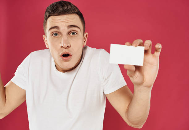 istock Man gesturing with his hands over red background with business card mockup 2051821781