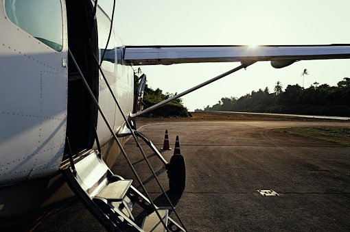 On a desolate island, a small aircraft sits parked on the beach, its turboprop engine gleaming in the sunlight. It stands as the sole connection, bridging this isolated island with the outside world, offering hope and possibilities for adventurers. Captured with the Leica Q3.