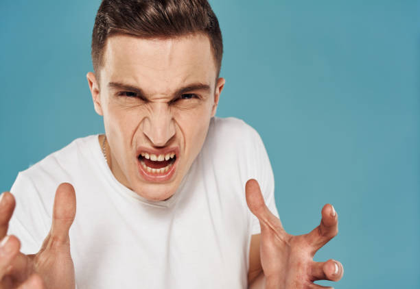 istock Angry man white t-shirt emotions cropped view blue background 2051844634