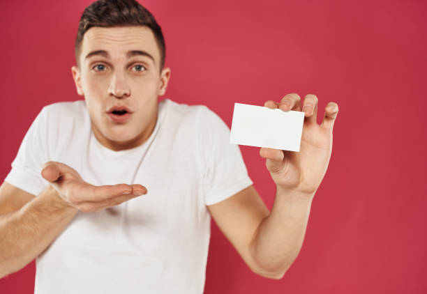 istock Man gesturing with his hands over red background with business card mockup 2051846706