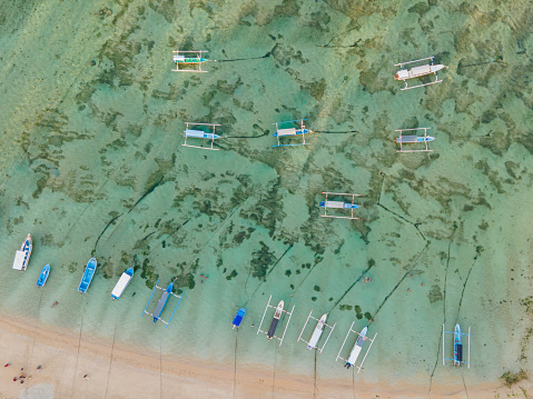 Fishing boats and tourism boats seen from a top view at Sanur Beach Bali. Sanur Beach is one of the favorite locations for tourists in Bali, Indonesia.