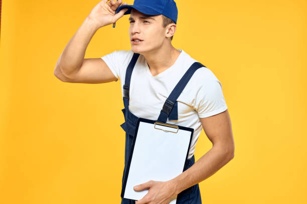 istock Man in working uniform documents rendering of services delivery service yellow background 2051871590
