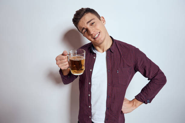 istock Cheerful man with mug of beer alcohol emotions light background 2051899191