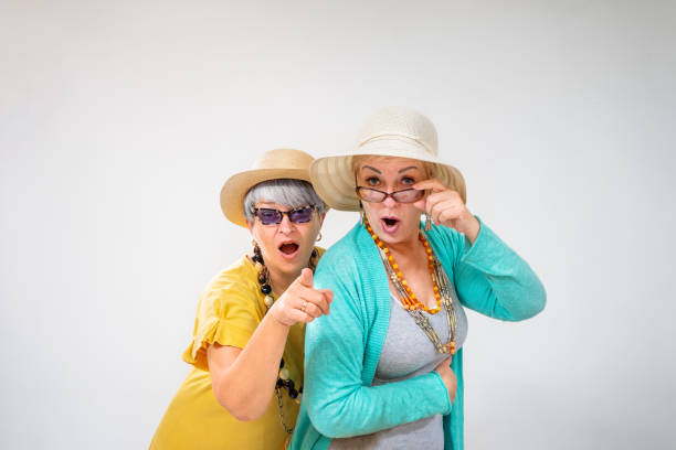Senior female friends looking at camera with surprise
