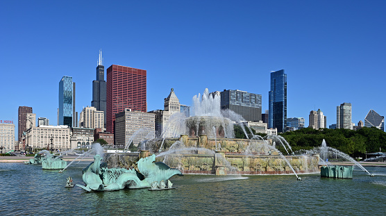 Chicago, Illinois - August 9, 2019: Buckingham Fountain and Chicago skyline from Grant Park on clear sunny summer morning.
