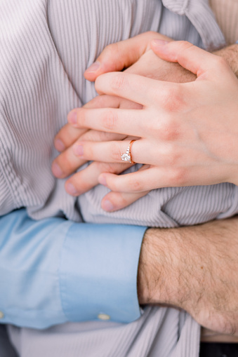 Couple in love are embracing with their hands together and hugging together.