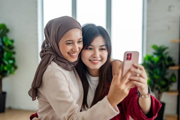 istock multiracial female friends taking selfie and laughing 2051991349