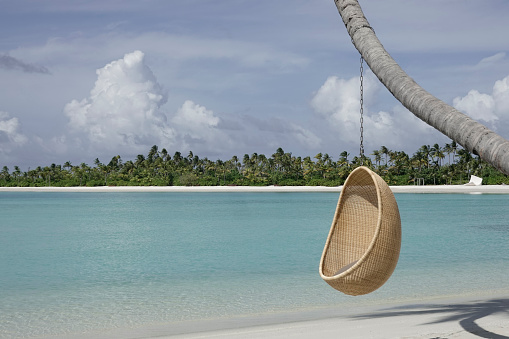 The swing hangs on the white sand beach of the Maldives, forming a semi-circular landscape, giving a sense of tranquility and comfort. Captured with the Leica Q3.