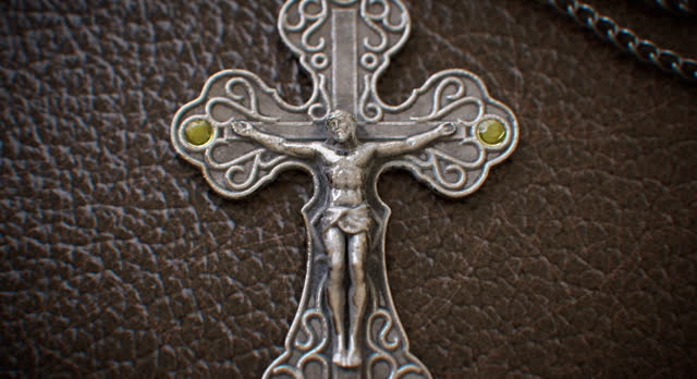 A leather-bound religious text adorned with a metallic crucifix