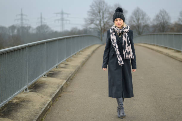 istock Blonde lady looking friendly into the camera while walking towards 2052057918