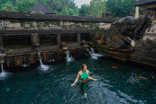 istock Woman doing purifying ritual in  Tirta Empul holy spring 2052063067