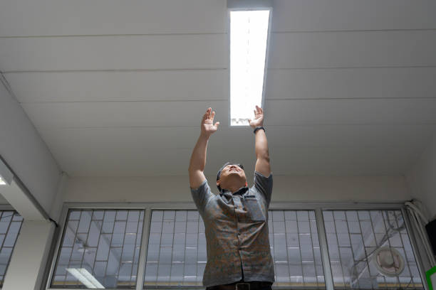 istock High angle shot energy-saving light bulb in a white lamp on the ceiling, checking or replacing fluorescent lights in buildings. 2052064035