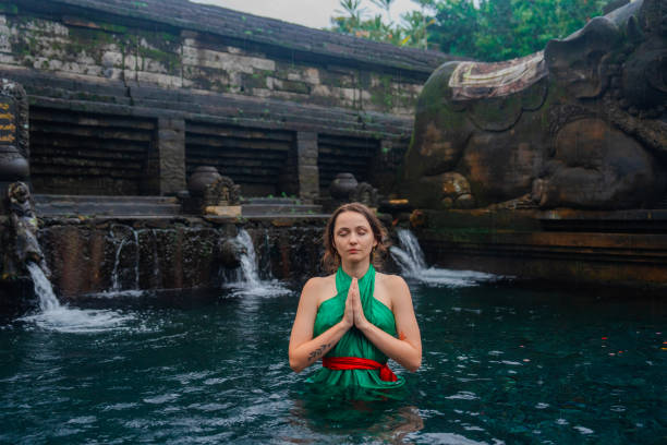 Woman doing purifying ritual in  Tirta Empul holy spring in Ubud, Bali, Indonesia