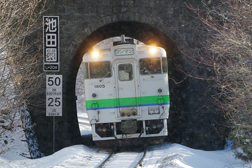 Nanae-cho, Hokkaido, Japan - February 24, 2024 : KIHA 40 Local train coming through the tunnel