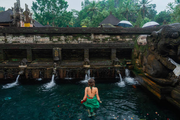 istock Woman doing purifying ritual in  Tirta Empul holy spring 2052064095