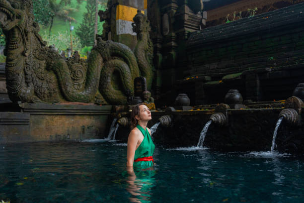 istock Woman doing purifying ritual in  Tirta Empul holy spring 2052064601