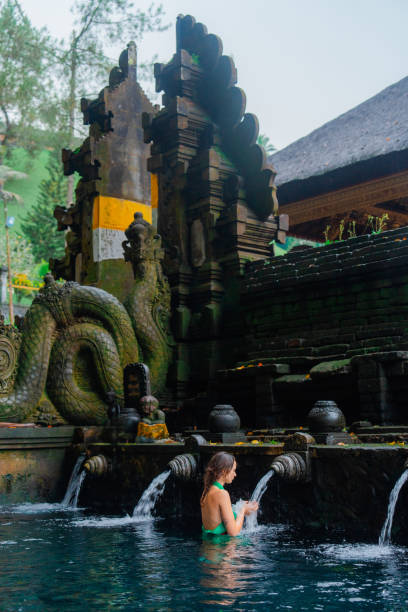 istock Woman doing purifying ritual in  Tirta Empul holy spring 2052065111