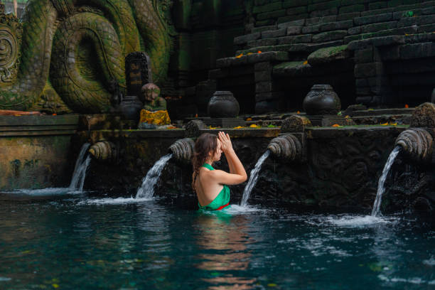 istock Woman doing purifying ritual in  Tirta Empul holy spring 2052066660