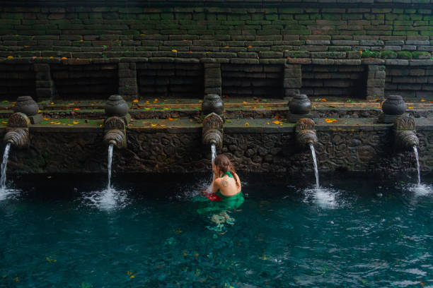 istock Woman doing purifying ritual in  Tirta Empul holy spring 2052067679
