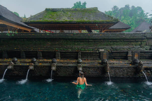 istock Woman doing purifying ritual in  Tirta Empul holy spring 2052068740