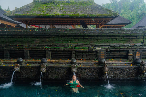 istock Woman doing purifying ritual in  Tirta Empul holy spring 2052069247